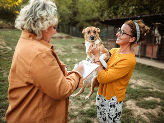 two woman with a dog in the yard